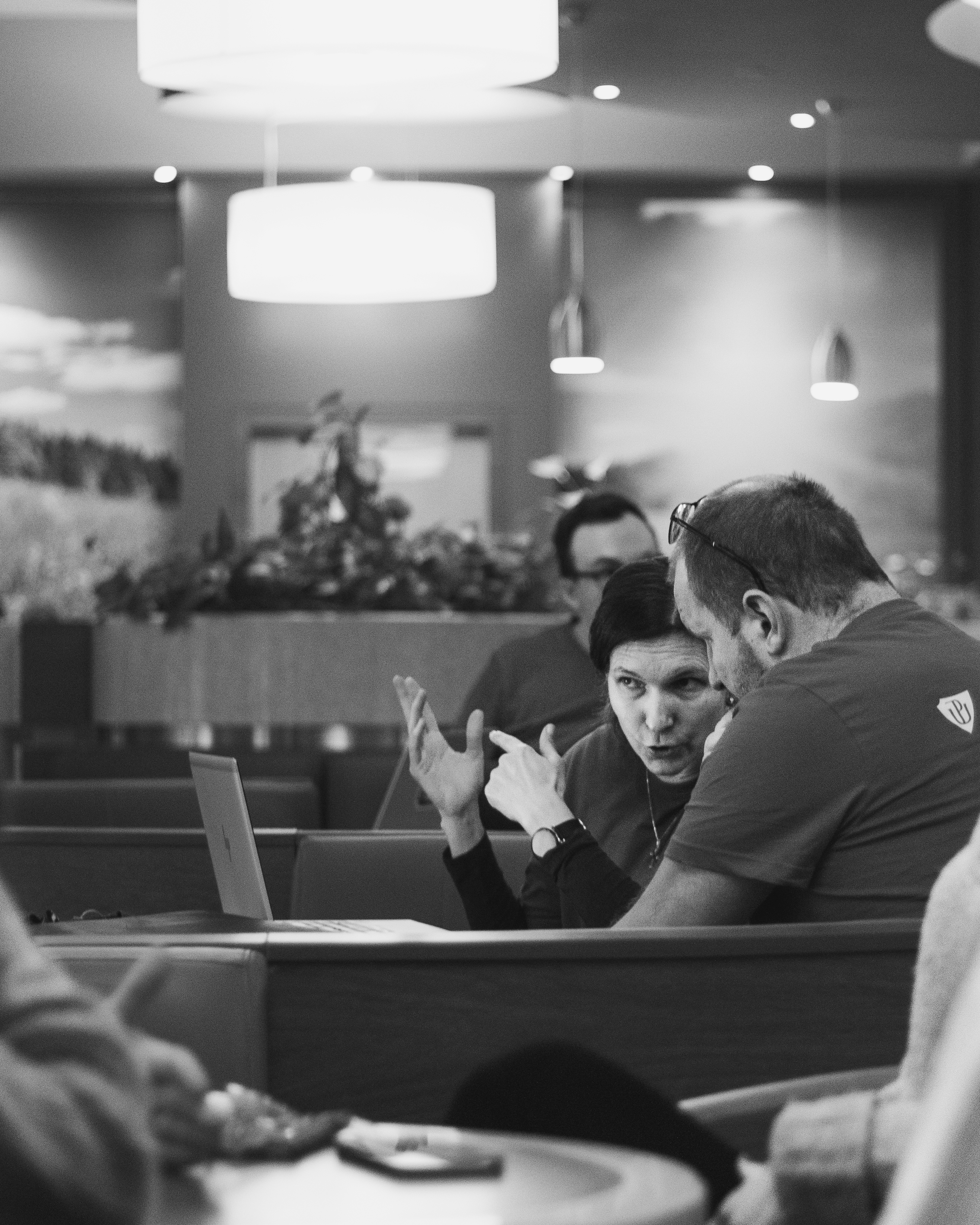 Dva muži se dívají na monitor na pódiu, černo-bílá fotografie